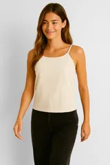 Top color crema de breteles finos, corte al cuerpo y cuello halter.