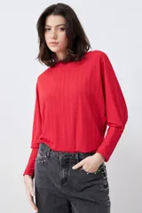 Blusa roja de tejido de punto acanalado, con escote barco y mangas dolman largas.