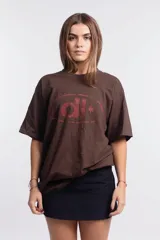 Remera marrón de corte holgado con estampado de elipse y estrella en color rojo.