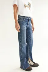 Pantalón de jean azul con corte recto y tajo en la pierna.