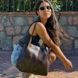 Cartera tote de cuero color marrón oscuro, con doble asa de hombro, cierre superior y bolsillo interno.