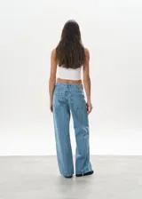 Pantalón de jean celeste con rayas verticales, tiro bajo y corte wide leg.