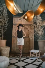 Chaleco negro de vestir, con escote en V y cierre frontal de botones dorados.