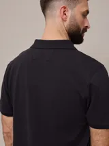 Remera polo color beige, de piqué de algodón, con cuello clásico y tapeta de dos botones.