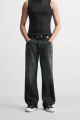 Pantalón de jean negro con efecto lavado, corte flare, cinco bolsillos, cierre frontal con cremallera y botón, y bajo con acabado irregular.