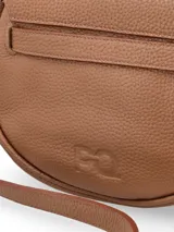 Bandolera de cuero color crudo con detalles en marrón. Tiene correa larga regulable y cierre con broche metálico.