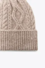Gorro de lana color rosa con diseño de punto trenzado.