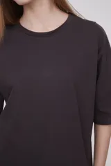 Remera color marrón de corte holgado, con cuello redondo y mangas cortas.