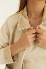 Campera de cuero con flecos en la espalda y cierre frontal, diseño moderno.