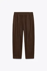 Pantalón bombacho color beige de lino, con cintura elástica, bolsillos frontales y bolsillos de parche en la espalda.
