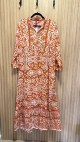 Vestido amplio color naranja con estampado blanco, cuello mao y mangas 3/4.