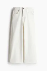 Pantalón jean blanco de corte ancho, tiro alto y largo tobillero. Confeccionado en denim de algodón levemente elástico, con cinco bolsillos, cierre frontal con botón y pierna amplia.