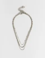 Collar corto dorado de tres capas con diferentes tipos de cadenas de metal.