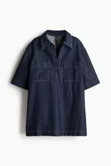 Vestido corto de denim azul oscuro, corte recto, con cuello camisero con escote en V, manga corta y dos bolsillos de parche en el pecho.