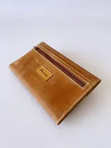 Billetera de cuero color camel con sistema de cierre con broche y monedero externo.