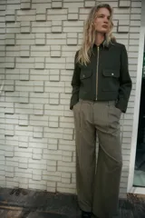 Pantalón de tiro alto con bolsillos delanteros, pinzas y cierre frontal con cremallera y gancho metálico.
