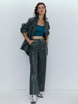 Pantalón de cuero verde oscuro, de corte recto y tiro alto.