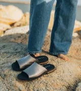 Sandalias bajas de cuero vacuno color negro, con suela de goma y horma de punta redonda. Producto de horma chica, se recomienda pedir un talle más.