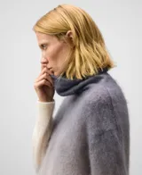Sweater de punto cardado con diseño degradado en tonos grises y beige. Presenta cuello chimenea, manga larga con hombro caído y remates en canalé. Confeccionado en una mezcla de mohair y lyocell.