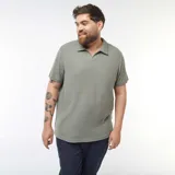 Remera polo de piqué color verde oliva, de corte clásico y manga corta.