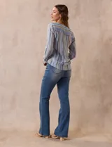 Blusa de gasa estampada a rayas verticales en tonos celeste, lila, naranja y marrón. Tiene cuello a la base con escote en V y botones. Delantera con bolsillo aplicado. Largo de manga regulable con presilla y botón. Terminación anudada opcional.