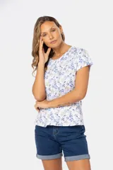 Remera blanca estampada con flores azules y beige, de manga corta y cuello redondo.