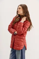 Campera color ladrillo con matelassé de corazones, corte amplio, mangas largas y bolsillos con solapa y botones snap en el frente.