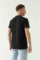 Chomba azul marino de manga corta con cuello polo y detalles de líneas grises en cuello y mangas. Tiene logo bordado en el pecho. Corte regular.