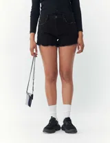 Short de denim con diseño desgastado, con dobladillo sin terminar y corte ajustado.