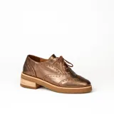 Zapato acordonado color bronce de cuero vacuno con perforaciones decorativas, taco de madera con folia en cuero de 4cm y entre suela de goma de 1,5cm. Horma de punta redonda y cómoda.