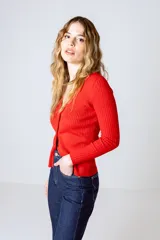Cardigan de punto fino color beige, con escote en V y cierre frontal con botones.