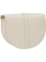 Cartera saddle color crema de Tommy Hilfiger, con correa ajustable y extraíble, cierre magnético, dos compartimentos principales y un compartimento con cremallera.