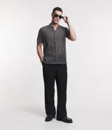 Camisa de punto gris con cuello inglés, mangas cortas, abotonadura frontal y textura geométrica.