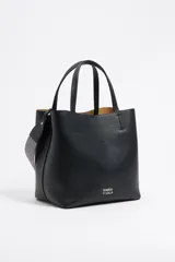 Bolso tote negro de cuero vacuno con doble asa corta y correa de tela extraíble. Interior con tres compartimentos y bolsillo con cremallera. Logo metálico de la marca en el frente.