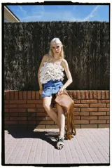 Top strapless color crema con volados estructurados en la parte delantera y elástico en la espalda.