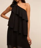 Vestido corto blanco de chiffon con un solo hombro y volados superpuestos.