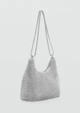 Bolso de mano dorado con apliques de cristales facetados, doble asa corta y asa larga de cadena.