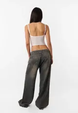 Corset negro de breteles finos y copas preformadas, con cierre frontal de ganchos y ballenas.