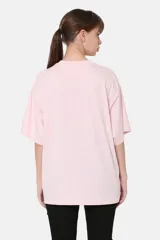 Remera rosa de corte holgado con estampado de paisaje montañoso con río y flores.