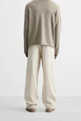 Pantalón de pana color crema, corte relaxed fit, con bolsillos frontales, bolsillos de parche en la parte trasera, bolsillos laterales en las piernas, trabilla multifunción y cierre con cremallera y botón.