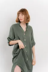 Vestido camisero midi color verde militar, de lino 100%, con silueta oversize, cuello camisero, mangas 3/4 con botón para ajustar y aberturas laterales.