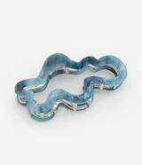 Pinza para el pelo con diseño orgánico cutout y patrón marmolado en tonos celeste y blanco.