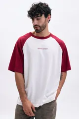 Remera de mangas cortas ranglan, con cuerpo blanco y mangas y cuello en color bordó.