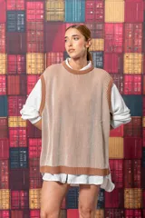 Chaleco de punto color beige con rayas verticales marrones y cuello redondo.