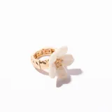 Anillo dorado con banda elástica y aplique de flor blanca con glitter.