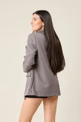 Blazer negro de corte sastre, con solapas de muesca, cierre frontal con un botón y bolsillos delanteros con solapa.