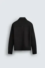 Sobrecamisa color beige de tejido efecto ante, corte regular fit, con cuello solapa, manga larga con puños abotonados, bolsillos de parche con solapa en el pecho y bolsillos de ojal en la cadera.
