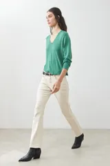 Sweater verde de tejido de punto, con escote en V y mangas largas.