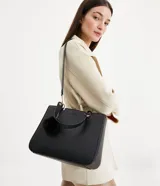 Bolso satchel negro con correa de mano fija y correa bandolera desmontable. Incluye llavero de pompón.
