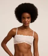 Soutien sin copa con aro, confeccionado en encaje floral color blanco. Presenta tirantes finos regulables y removibles, y cierre trasero con gancho.